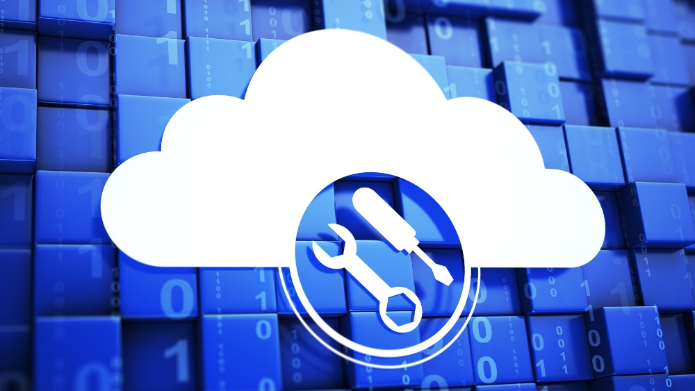 Pros and Cons of AWS native tools in managing cloud costs - pic of a cloud with a wrench and screwdriver anc code in the background